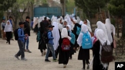 FILE - Afghan students leave school classes in a primary school in Kabul, Afghanistan on March 27, 2021. 