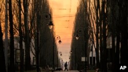 A man walks at dusk in Kyiv, Ukraine, March 19, 2022. 