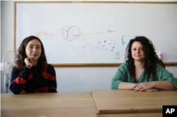 Volunteers Burcak Sevilgen, right, and Faina Karlitski pose for a photo at a space where they organized two school classes for Ukrainian refugees in Berlin, Germany, Monday, March 21, 2022. (AP Photo/Markus Schreiber)