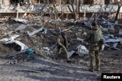 乌克兰军人查看基辅一座被俄军炮击毁灭的居民楼。(2022年3月15日)