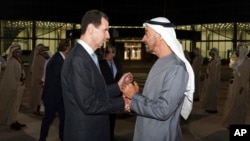 In this photo released by the official Facebook page of the Syrian Presidency, Syrian President Bashar Assad, left, speaks with Abu Dhabi's Crown Prince, Sheikh Mohammed bin Zayed Al Nahyan, in Abu Dhabi, United Arab Emirates, March 18, 2022. 