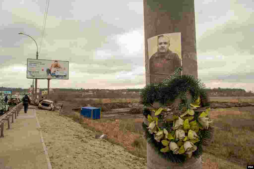The picture of a fallen Ukrainian soldier is displayed on a light post at the bridge that links Irpin to Kyiv, in Ukraine, March 13, 2022. 