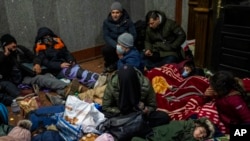 FILE - Afghans trying to flee Ukraine sleep inside a railway station, Feb. 28, 2022, in Lviv, in the western part of the country.