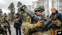 Anggota pasukan pertahanan terirtori Ukraina membawa senjata antitank NLAW di pinggiran Kota Kyiv, Ukraina, pada 9 Maret 2022. (Foto: AP/Efrem Lukatsky)