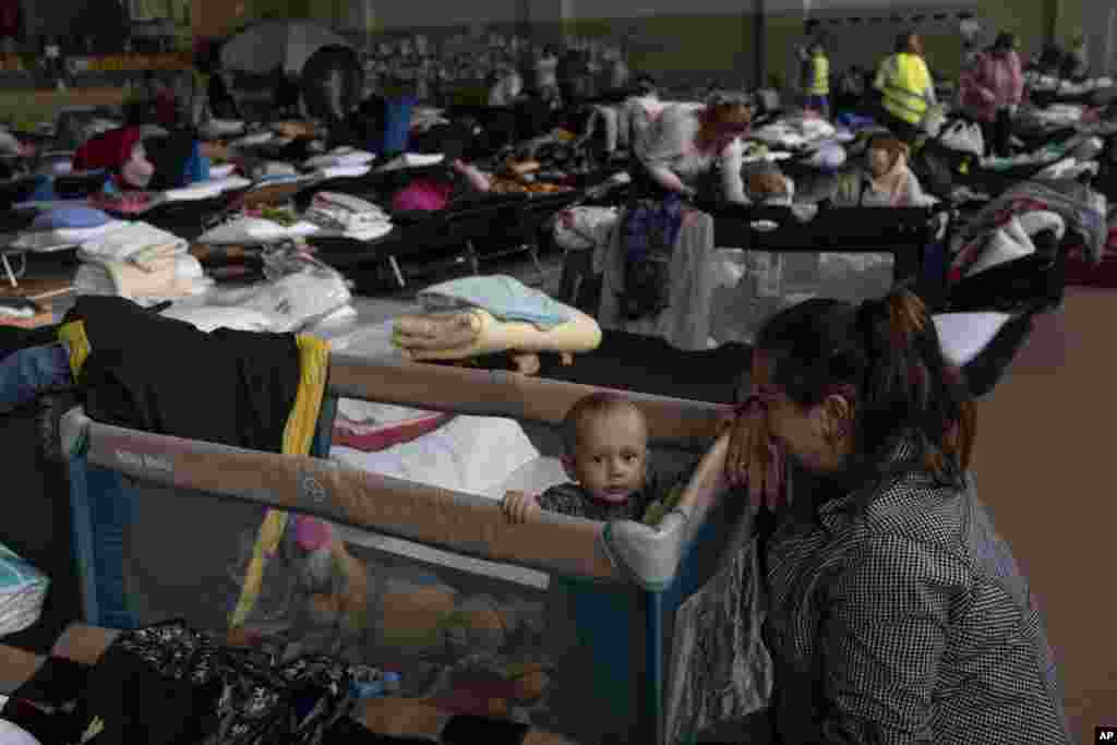 Vlad, de un año, y su madre Natasha, dentro de un estadio deportivo cubierto que se utiliza como centro de refugiados, en el pueblo de Medyka, un cruce fronterizo entre Polonia y Ucrania.