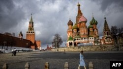 FILE - A woman walks near the Kremlin and St. Basil's Cathedral in central Moscow, Russia, Feb. 22, 2022. 