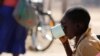 FILE - A child drinks water from a cup in drought-hit Masvingo, Zimbabwe.