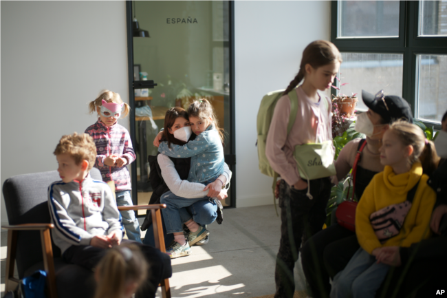 Refugee children from the Ukraine wait with their mothers for the start of their classes in Berlin, Germany, Monday, March 21, 2022. (AP Photo/Markus Schreiber)