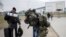 A man carries combat gear as he leaves Poland to fight in Ukraine, at the border crossing in Medyka, Poland, Wednesday, March 2, 2022. (AP Photo/Markus Schreiber, File)