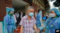 Un hombre sale de un centro en Hong Kong después de recibir una vacuna contra el COVID-19 el 19 de marzo de 2022.