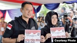 Calon gubernur Jakarta Agus Harimurti Yudhoyono bersama istri memberikan suara di sebuah TPS (15/2). (Courtesy: Anung Anindito)