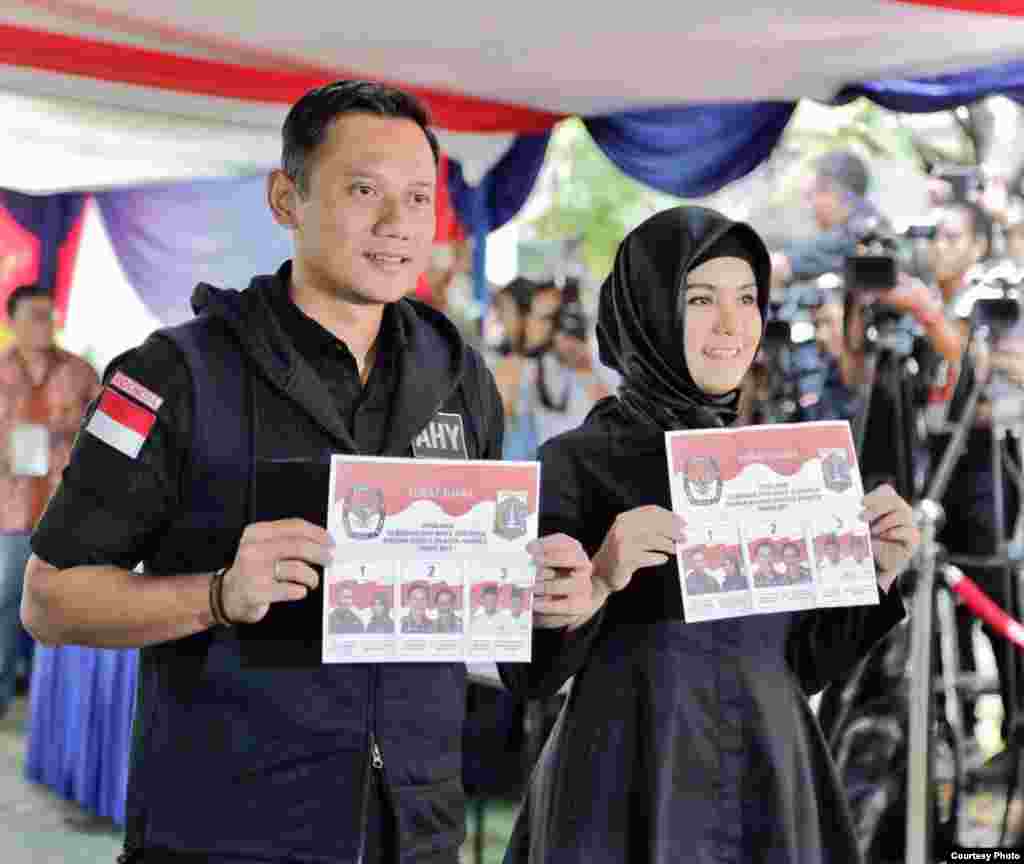 Calon gubernur Jakarta Agus Harimurti Yudhoyono bersama istri memberikan suara di sebuah TPS (15/2). (Courtesy: Anung Anindito)