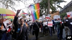 FILE - Supporters on both sides of the case line a walkway following a hearing before Washington's Supreme Court about a florist who was sued for refusing to provide services for a same sex-wedding, Nov. 15, 2016, in Bellevue, Wash.