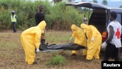 Trabajadores de la salud cargan el cuerpo de una víctima del virus del ébola en Waterloo, distrito de Freetown en Sierra Leona.