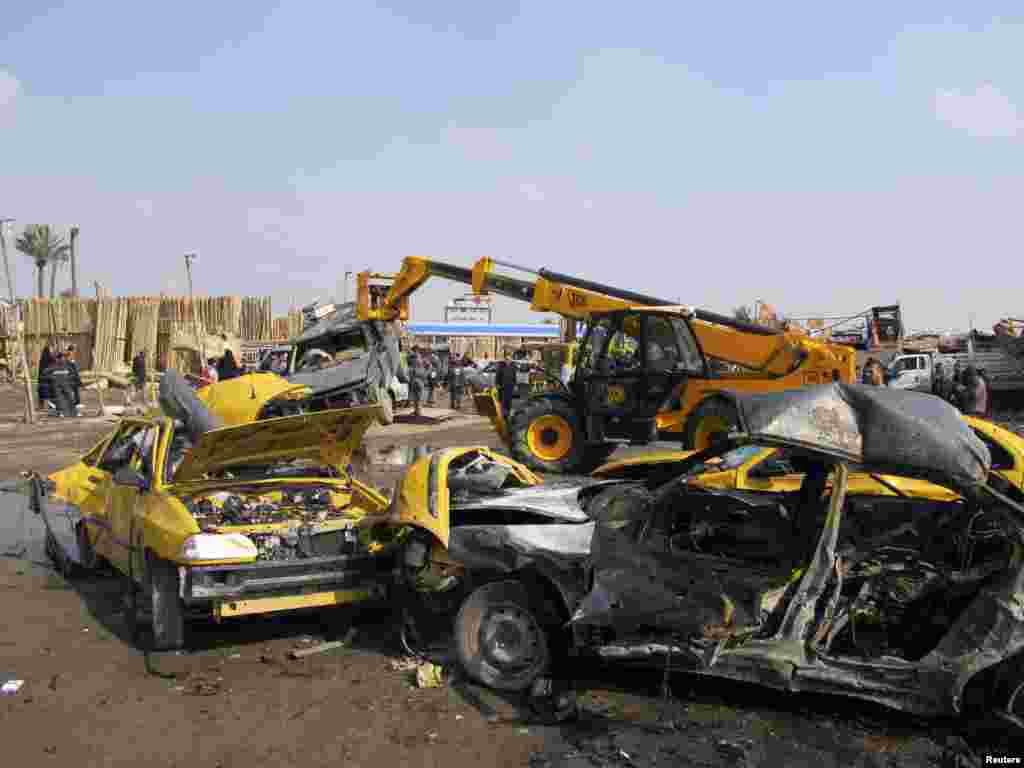 Security personnel and residents gather at the site of a car bomb attack in Kadhimiya, Iraq, Feb. 8, 2013.