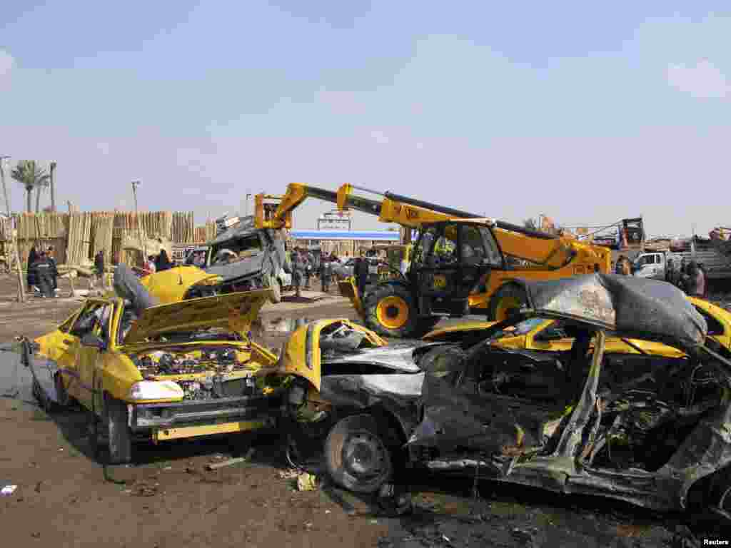 Security personnel and residents gather at the site of a car bomb attack in Kadhimiya, Iraq, Feb. 8, 2013. 