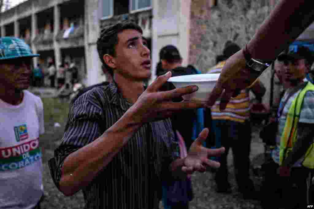 Migrants -mostly Hondurans- taking part in a caravan heading to the US, line up for food at an improvised shelter in an abandoned hotel, in Matias Romero, Oaxaca State, Mexico, on November 01, 2018.