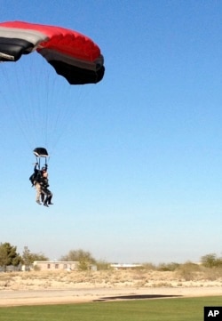 Former U.S. Rep. Gabrielle Giffords (r) comes in for a landing during a tandem skydive, Jan. 8, 2014, in Tucson, Arizona.