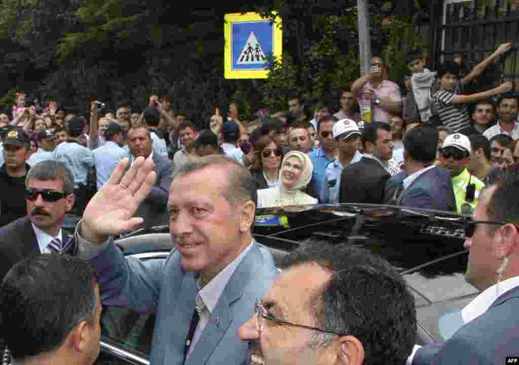 Turkey's Prime Minister Tayyip Erdogan greets his supporters as he leaves from a polling station in Istanbul June 12, 2011. Turks began voting in an election on Sunday that is expected to return Prime Minister Tayyip Erdogan to office for a third consecut