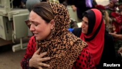 A newly internally displaced woman reacts upon her arrival at Al Khazar camp near Hassan Sham, east of Mosul, Iraq Oct. 28, 2016.