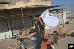 A man raises a white flag as he flees from a zone of conflict between the Iraqi military and Islamic State militants in Gogjali, on the eastern outskirts of Mosul, Iraq, Nov. 5, 2016.