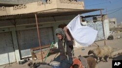 Seorang pria mengibarkan bendera putih saat melarikan diri dari zona konflik antara militer Irak dan militan ISIS di Gogjali, pinggiran timur kota Mosul, Irak, 5 November 2016. 