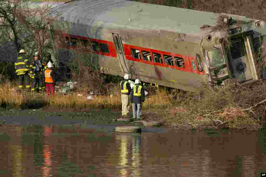 Officials with the National Transportation Safety Board inspect a derailed Metro North commuter train where it almost fell into the Harlem River, Dec. 1, 2013 in the Bronx borough of New York. 