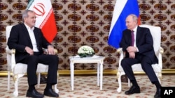 Presiden Rusia Vladimir Putin, kanan, mendengarkan Presiden Iran Masoud Pezeshkian selama pertemuan mereka di sela-sela Forum Internasional "Interkoneksi Zaman dan Peradaban" pada 11 Oktober 2024. (Foto: via AP)