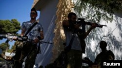 An Israeli soldier checks his weapon near the border with Gaza, August 6, 2014.