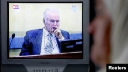 Mejra Dzogaz watches the television broadcast of the court proceedings of former Bosnian Serb general Ratko Mladic's in her home in Potocari, near Srebrenica, May 17, 2012