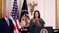 FILE - US President Joe Biden looks on as US Vice President Kamala Harris delivers remarks on advancing the safe, secure, and trustworthy development and use of artificial intelligence, in the East Room of the White House in Washington, DC, on October 30, 2023.