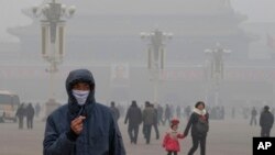 FILE - A man wears a mask on Tiananmen Square in thick haze in Beijing.