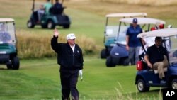 Presiden AS Donald Trump melambaikan tangan pada para demonstran di klub golf Turnberry di Skotlandia, Sabtu, 14 Juli 2018.