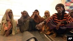 Somali refugee Mohamed Ibrahim (R) prepares to bury his son Sahro Mohamed, 1, who died of malnutrition in Ethiopia's Kobe camp, August 13, 2011