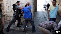 AFP Israeli photographer Menahem Kahana (C) is roughed up by an Israeli policeman during a demonstration in a street in the Muslim quarter of Jerusalem's Old City, on October 4, 2015, as Israel took a rare and drastic step of barring Palestinians from the