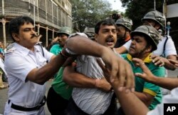 FILE - Police detain activists of Socialist Unity Center of India-Marxist (SUCI-M) during a protest demonstration against a recent case of child trafficking in West Bengal state in Kolkata, India, Nov. 29, 2016.