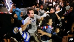 A Trump supporter clashes with protesters outside a rally for Republican presidential candidate Donald Trump, Thursday, April 28, 2016 in Costa Mesa, Calif. (AP Photo/Chris Carlson)