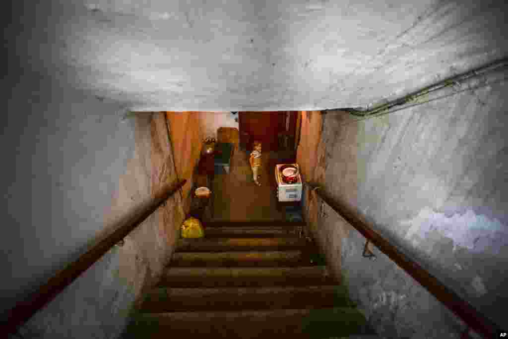 A little girl walks the stairs of the bomb shelter in Petrovskiy district in Donetsk, eastern Ukraine, Monday, Sept. 1, 2014. 