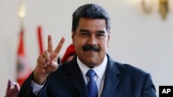 Venezuela's President Nicolas Maduro makes the victory sign after a meeting with former Spanish Prime Minister Jose Luis Rodriguez Zapatero at the presidential palace in Caracas, Venezuela, May 18, 2018. Maduro is seeking a new six-year mandate and, despite crippling hyperinflation and widespread shortages of food and medicine, he is widely expected to win it Sunday.