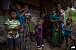 Members of the Caal Maquin family and neighbors stand in front of Claudia Maquin's house in Raxruha, Guatemala, Dec. 15, 2018. Claudia Maquin's daughter, 7-year-old Jakelin Caal Maquin, died in a Texas hospital, two days after being taken into custody by U.S. Border Patrol agents in New Mexico.