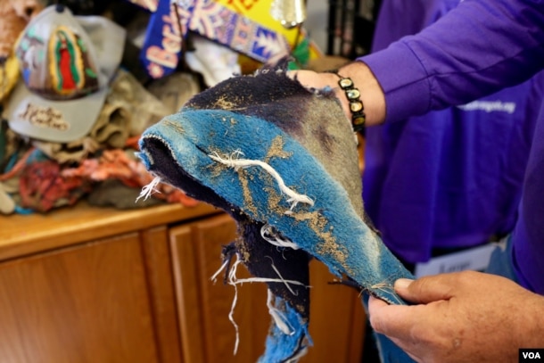 Border Angels’ Enrique Morones displays the remains of a cloth used by a migrant to wipe away tracks along the desert. (R. Taylor/VOA)