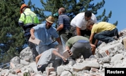 Rescuers work on a collapsed building following an earthquake in Amatrice, central Italy, Aug. 24, 2016.
