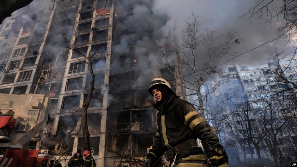 A firefighter walks outside a destroyed apartment building after a bombing in a residential area in Kyiv, Ukraine, March 15, 2022. (AP Photo/Vadim Ghirda)