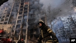 A firefighter walks outside a destroyed apartment building after a bombing in a residential area in Kyiv, Ukraine, March 15, 2022.