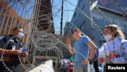 
15 Mart 2022 - Amerika-Meksika sınırının Meksika tarafındaki Tijuana kentindeki San Ysidro sınır kapısına gelen Rus vatandaşları, Amerikan Gümrük ve Sınır Güvenliği polisine insani vize başvurusu yapmak istediklerini söylüyor.