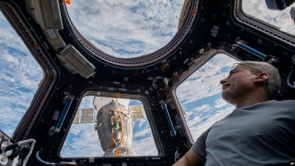 In this photo provided by NASA, U.S. astronaut and Expedition 66 Flight Engineer Mark Vande Hei peers at the Earth below from inside the seven-windowed cupola, the International Space Station's window to the world on Feb. 4, 2022. (Kayla Barron/NASA via AP)