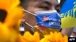 FILE - Taiwanese march on the streets protesting the war in Ukraine during a rally in Taipei on March 13, 2022.