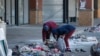 FILE - Two local women sort through debris following a looting at Diepkloof Square, Soweto, Johannesburg, July 14, 2021.