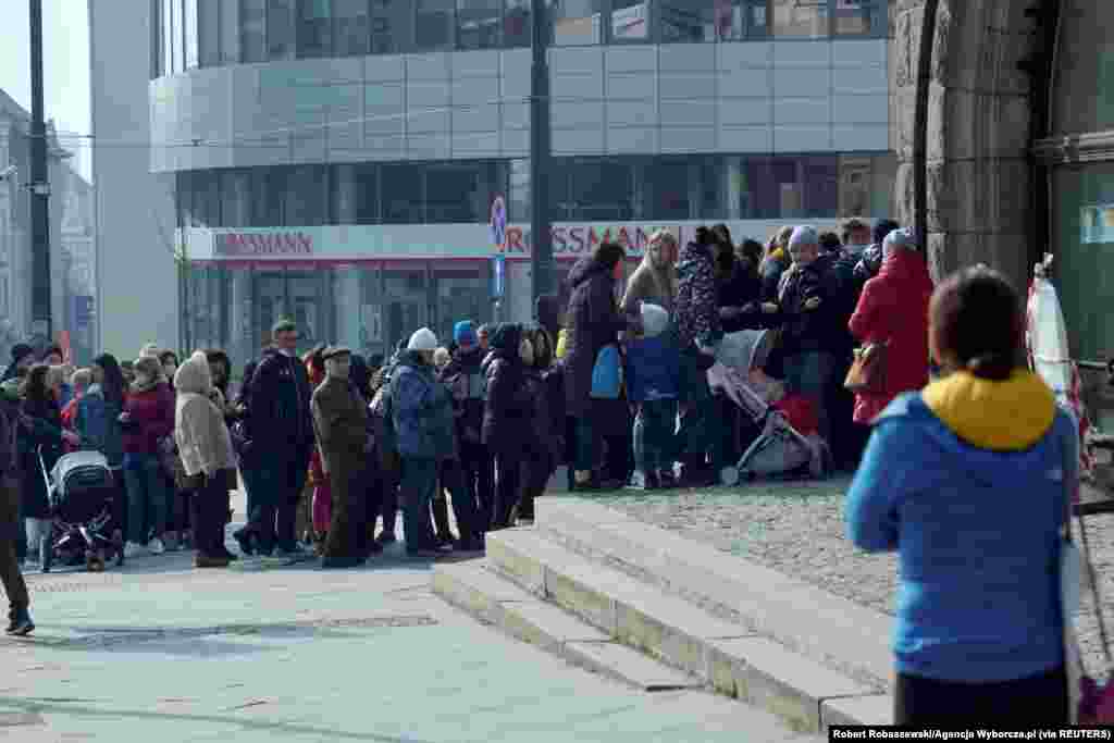 Refugees who fled Russia&#39;s invasion of Ukraine wait in a queue to obtain Polish national identification number (PESEL) in Olsztyn, Poland, March 16, 2022.