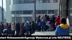 Refugees who fled Russia's invasion of Ukraine wait in a queue to obtain Polish national identification number (PESEL) in Olsztyn, Poland, March 16, 2022. 